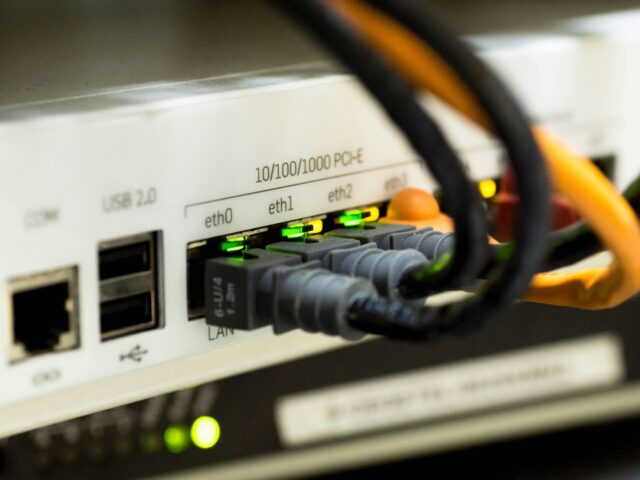 Detailed close-up of ethernet cables and network connections on a router, showcasing modern technology.